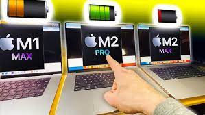 A person is pointing at several laptops with the word m2 pro on them.