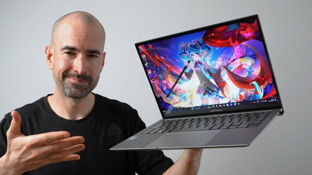 A man holding up an ASUS ZenBook OLED 13, revealing a captivating image on its display.